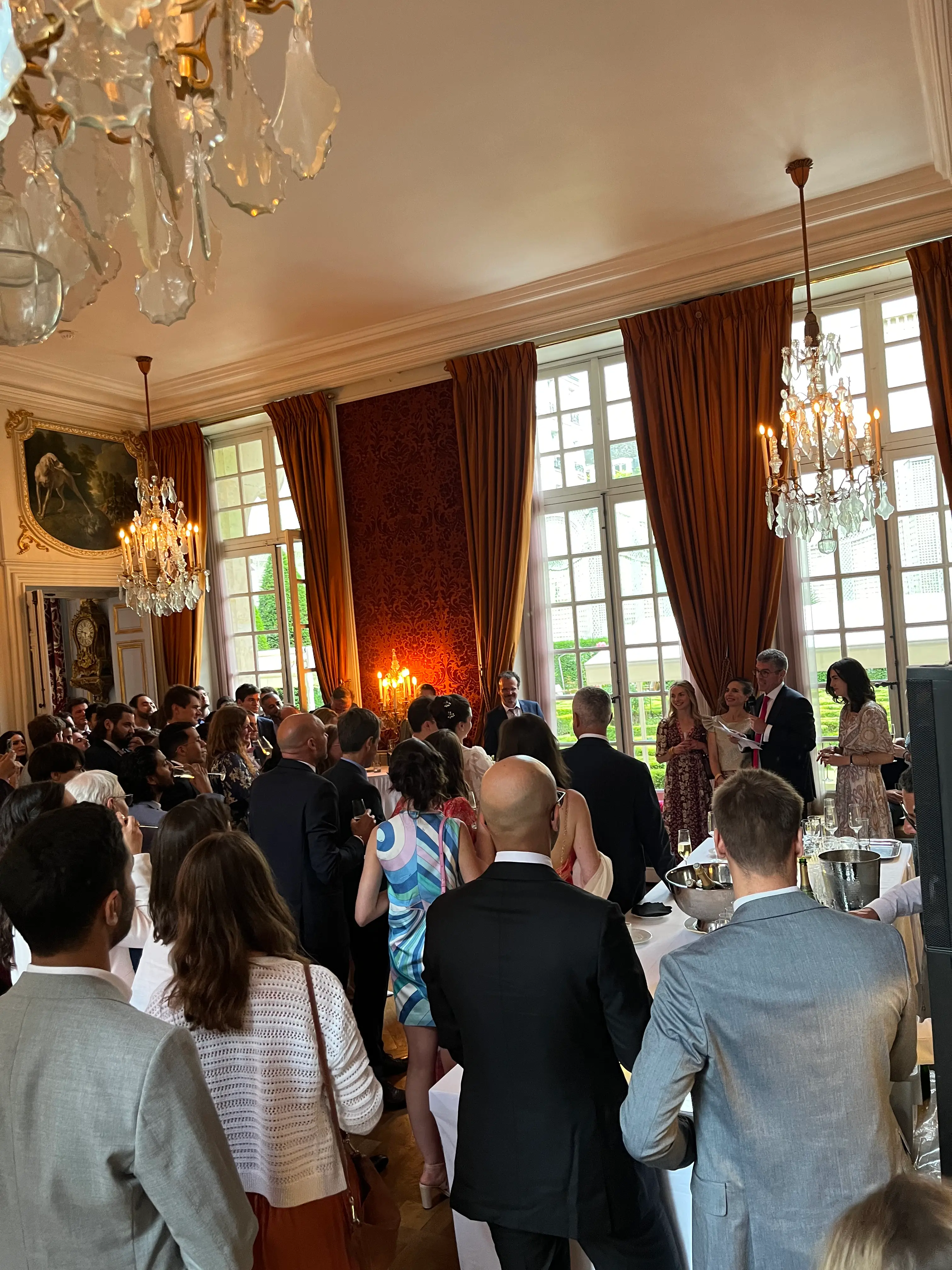 Invités debout dans un salon à lustres du Musée de la Chasse et de la Nature pendant les discours d'un mariage