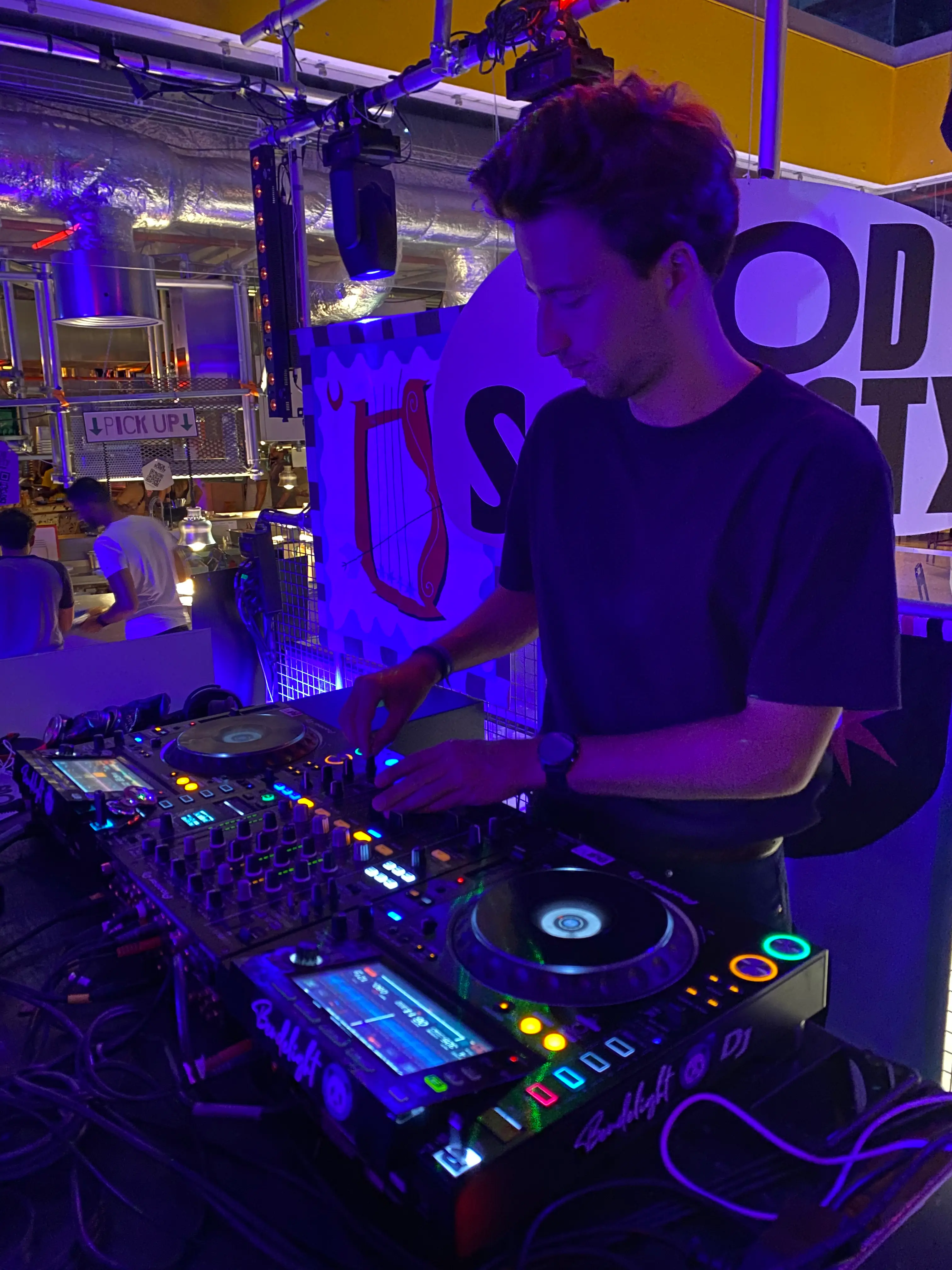 Sébastien de la Selle aux platines pendant une soirée au Food Society, sous des lumières violettes
